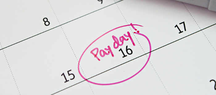 Business, finance, savings money, wages, payroll or accounting concept : Calendar with pink marker circle in word payday for remind; As Holiday Spending Rises, 60% of Americans Live Paycheque to Paycheque