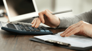 Person reviewing bankruptcy filing options and credit counseling certificate with forms and a calculator nearby