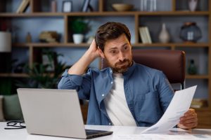 Individual reviewing Chapter 7 bankruptcy filing costs and legal fee estimates at a home desk