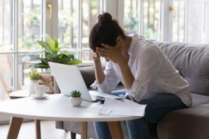 Person preparing Chapter 7 bankruptcy paperwork at home with laptop and documents