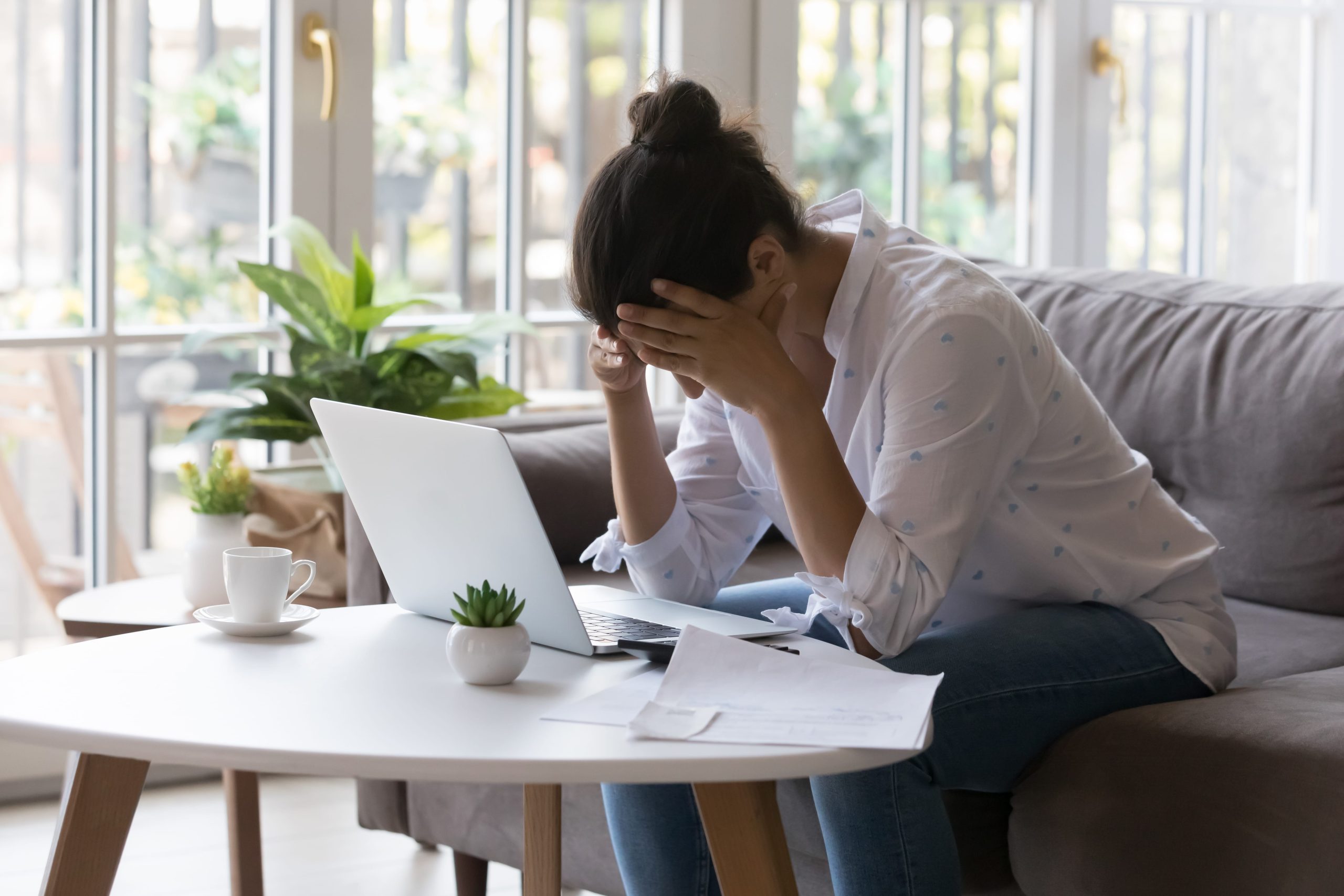 Person preparing Chapter 7 bankruptcy paperwork at home with laptop and documents