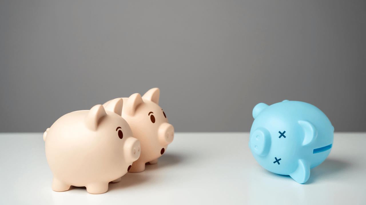 Three Piggy banks and one is laying down and blue as if it were dead
