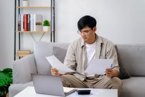 Man reviewing overdue bills and bankruptcy options at home