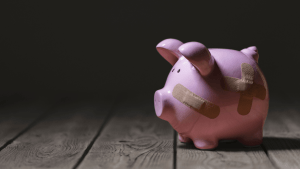 Piggy bank in the dark, seeming lost and broken.