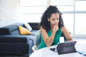 Woman looking concerned while researching bankruptcy on a tablet