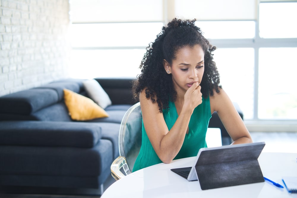 Woman looking concerned while researching bankruptcy on a tablet