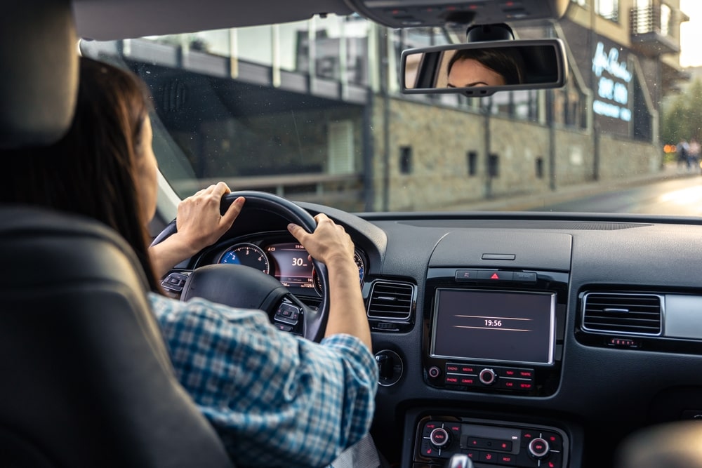 Woman driving a car and looking in the rearview mirror