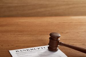 Bankruptcy judgment paperwork with a gavel on a wooden desk