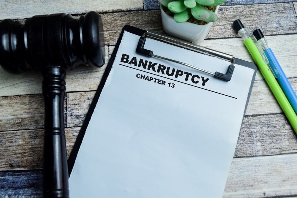 Chapter 13 bankruptcy paperwork on a clipboard next to the judge’s gavel and office supplies
