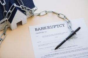Chapter 13 bankruptcy form with pen and chained house model