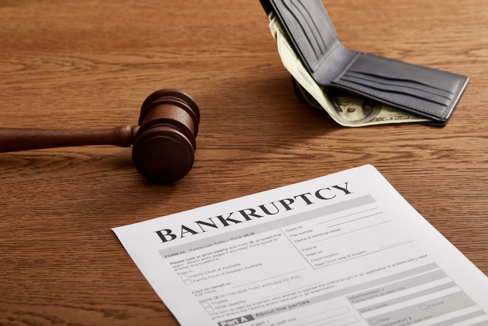 Bankruptcy form with gavel and wallet on wooden desk