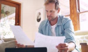 Concerned man reviewing paperwork related to Chapter 13 bankruptcy filing