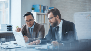 Two bankruptcy attorneys discussing will I lose my home if I file bankruptcy with client documents on desk