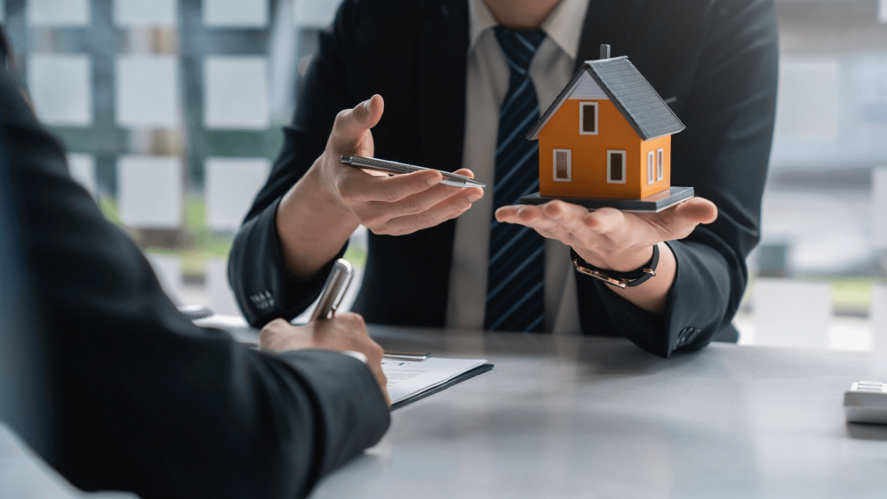 Real estate agent explaining can you buy a house if you file bankruptcy to client with model home and keys