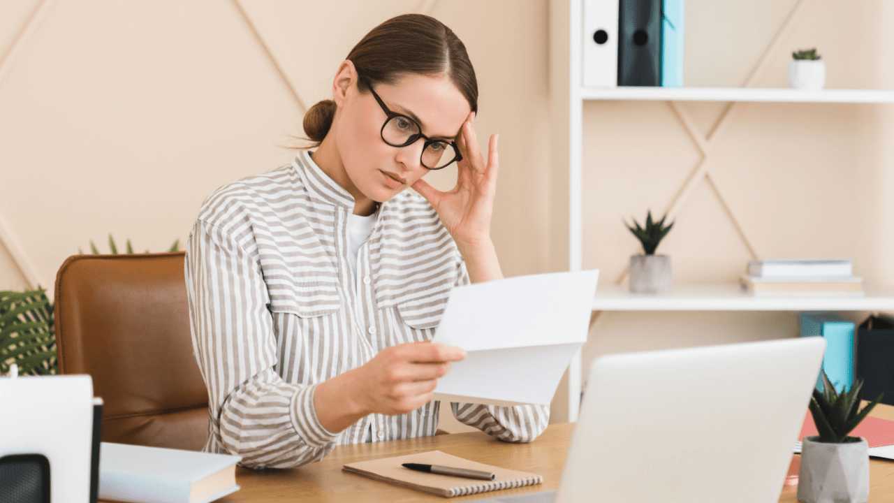 Woman stressed about student loan debt wondering can you file bankruptcy for student loans while reviewing financial documents