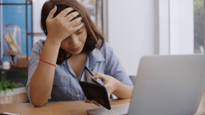 Woman stressed about finances wondering does it cost money to file bankruptcy while looking at empty wallet