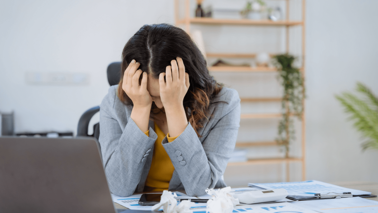 Stressed woman at desk wondering if you file for bankruptcy which debts are forgiven