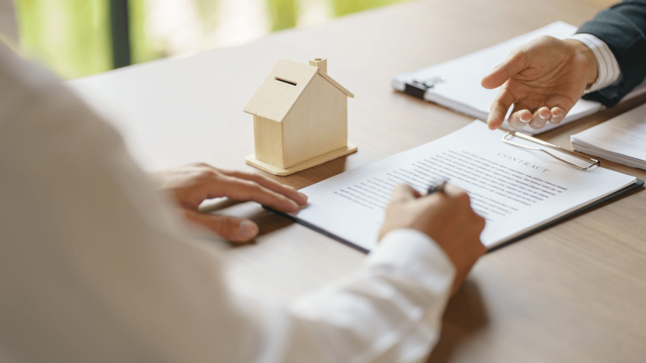Mortgage professionals reviewing loan documents explaining how long after you file bankruptcy can you buy a house with wooden house model on desk
