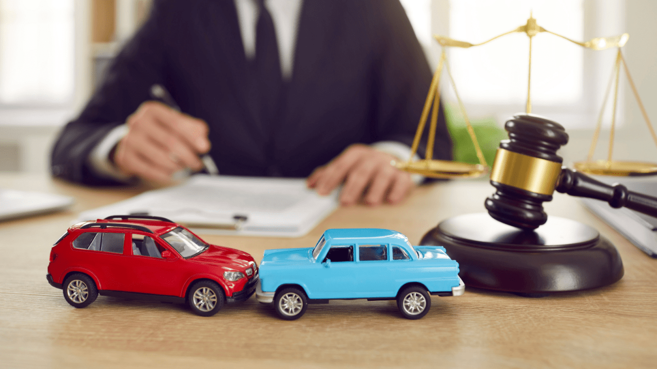 Two toy cars on lawyer desk with gavel and scales showing how to file bankruptcy and keep my car