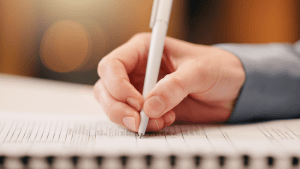 Person writing notes about what kind of loan debt is not alleviated when you file for bankruptcy on lined paper