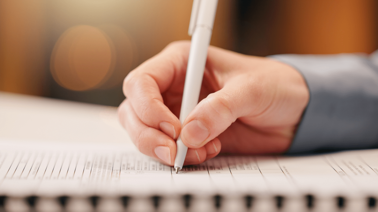 Person writing notes about what kind of loan debt is not alleviated when you file for bankruptcy on lined paper