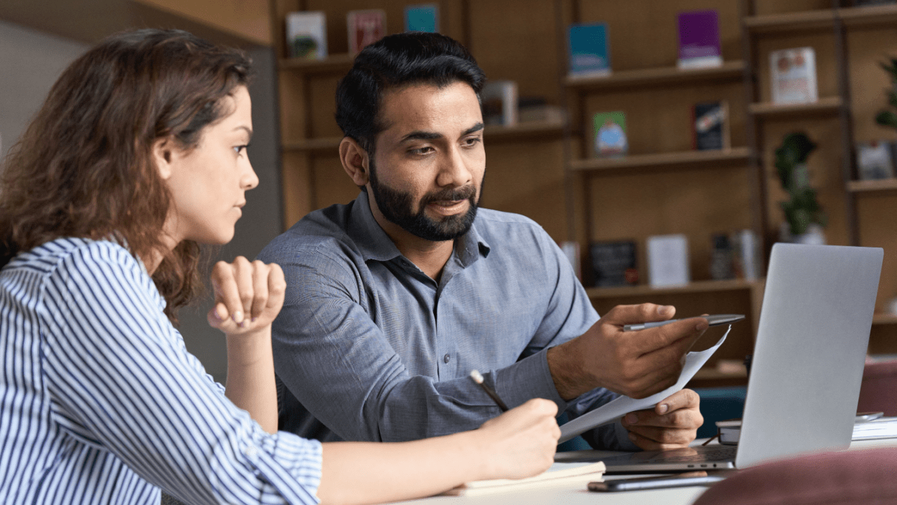 Two people discussing Chapter 7 bankruptcy lawyer fees while reviewing legal documents at a desk