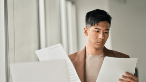 Young man reviewing financial documents to determine how much disposable income for Chapter 7 bankruptcy qualification
