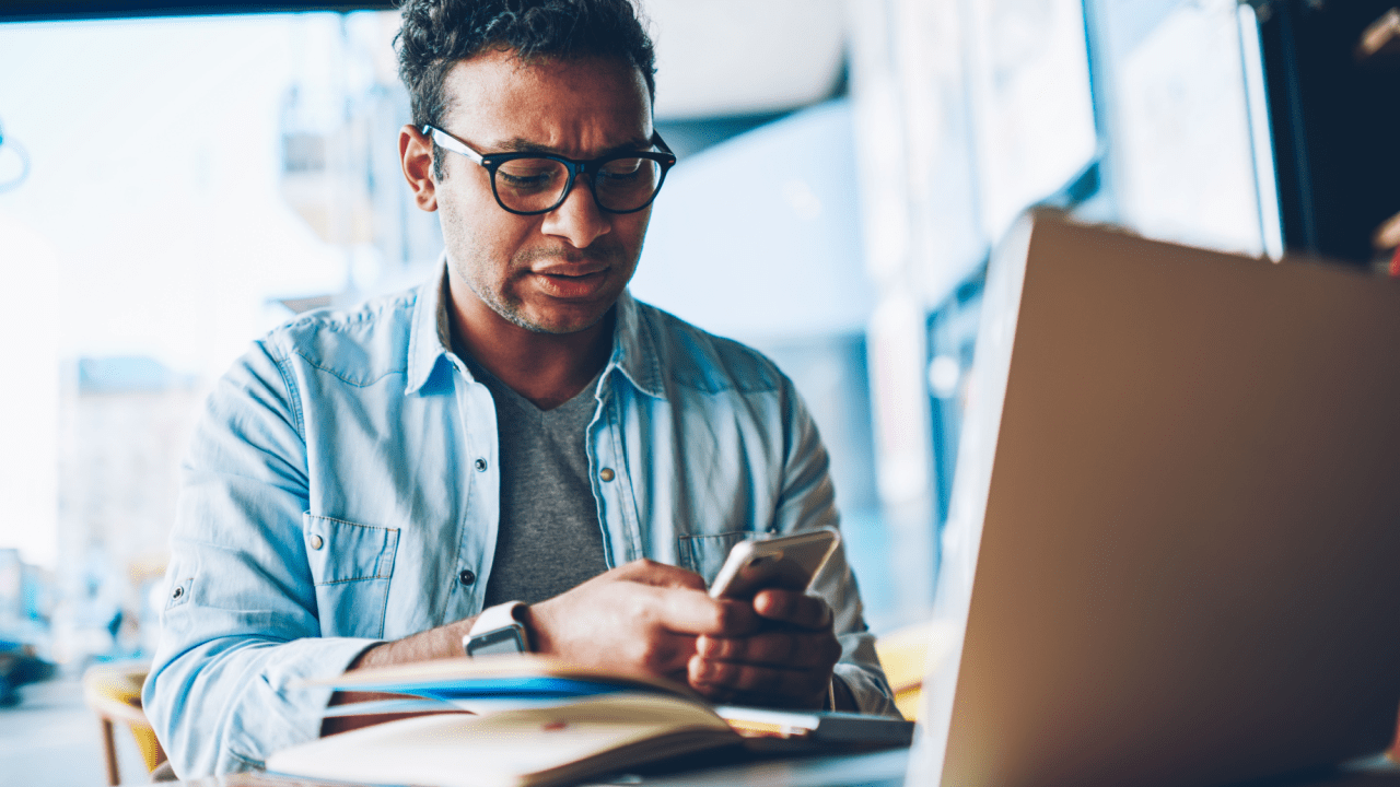 Man with phone and laptop researching do you lose your car if you file bankruptcy