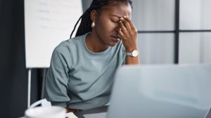 Stressed woman at laptop researching how much does it cost to file for bankruptcy chapter 7