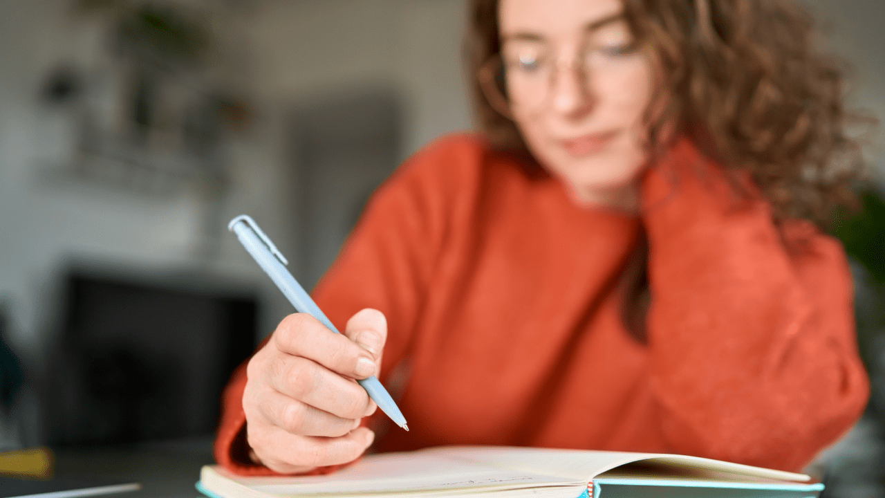 Woman writing in notebook researching can you file for bankruptcy and keep your house