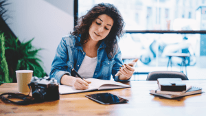 Woman with phone and notebook considering should i file bankruptcy for credit card debt