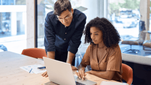 Bankruptcy attorney guiding client through bankruptcy process on laptop in modern office
