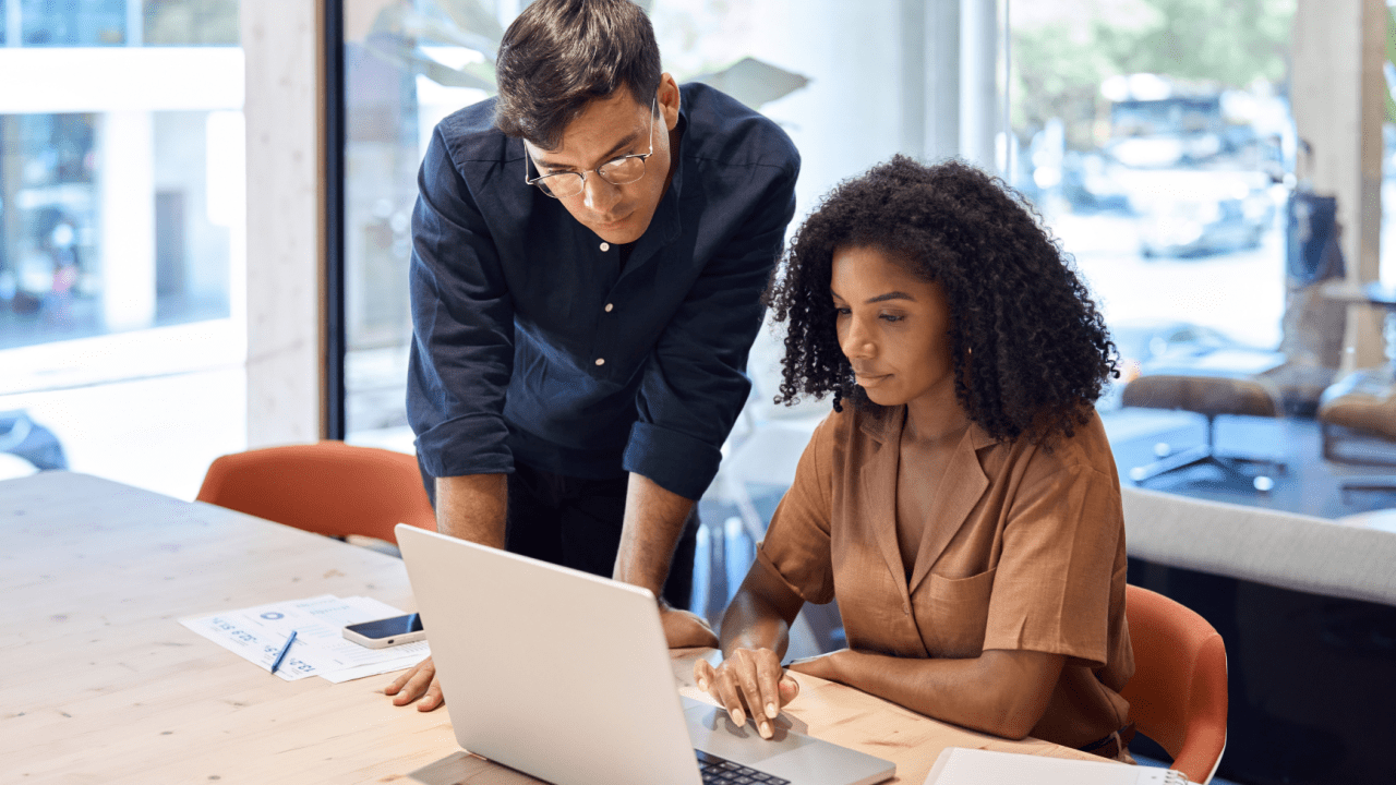 Bankruptcy attorney guiding client through bankruptcy process on laptop in modern office