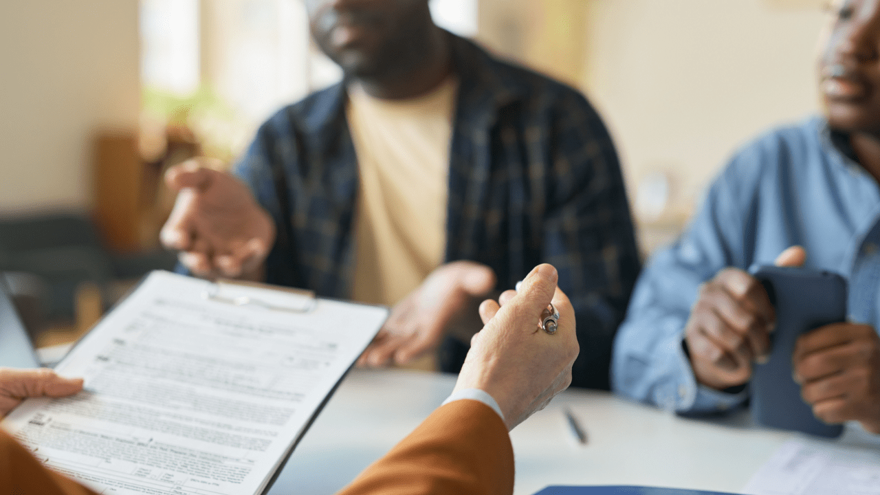 Attorney explaining debt discharge process during bankruptcy consultation meeting with clients