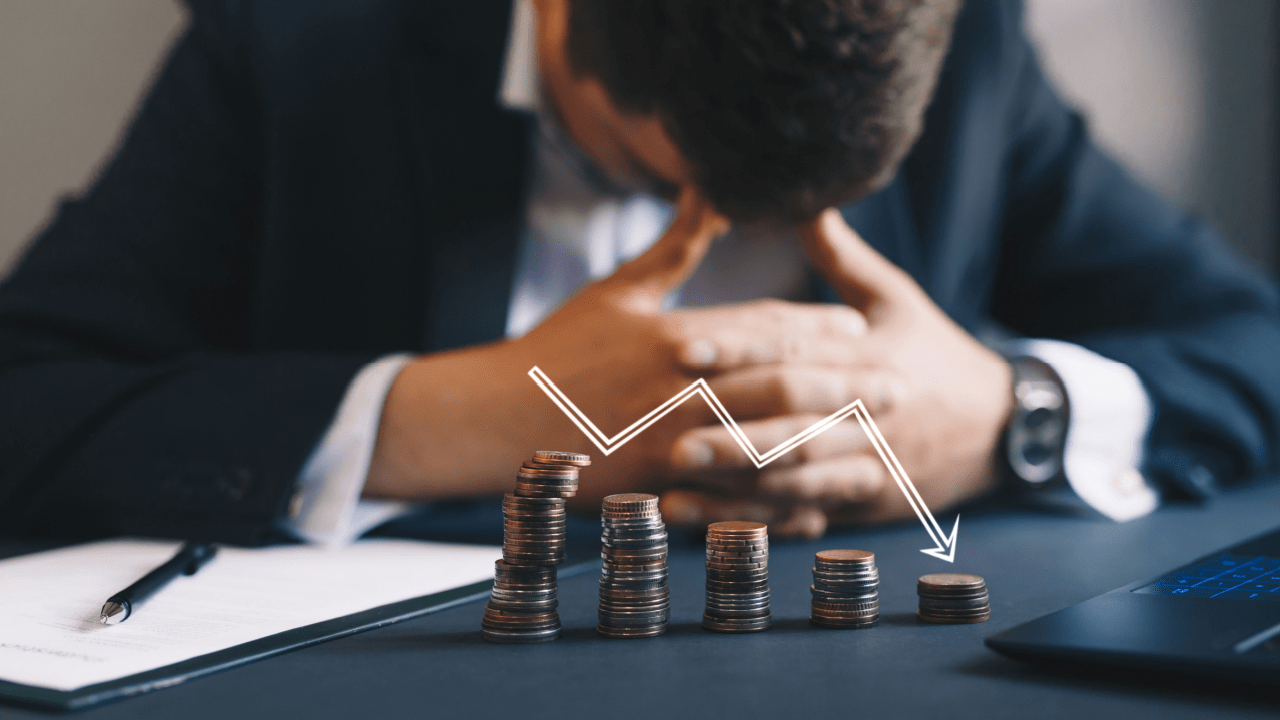 Worried person reviewing finances with declining coin stacks illustrating what are the two major types of bankruptcy decisions