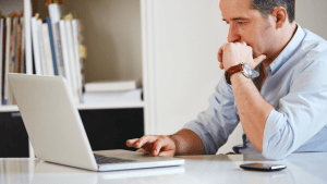 Worried man researching why are bankruptcies considered bad on laptop at home office