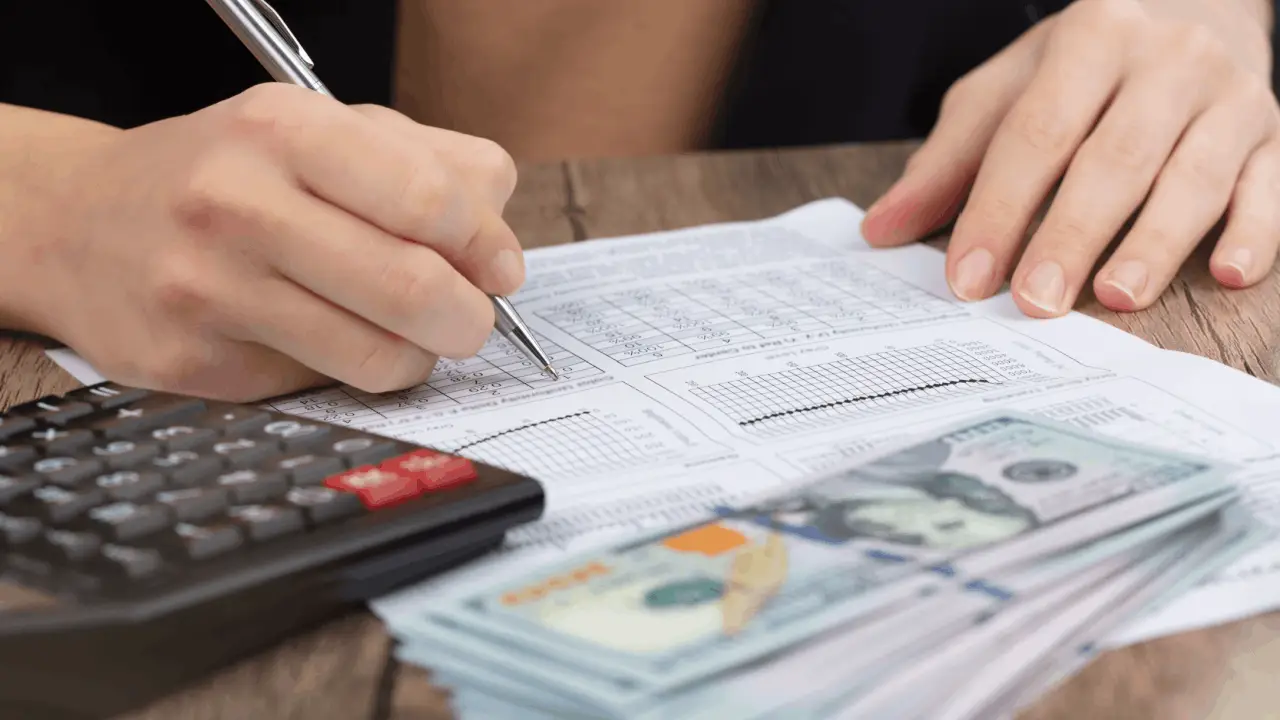 Person calculating Chapter 13 bankruptcy payment plan with calculator and cash showing does Chapter 13 take all my money budget analysis