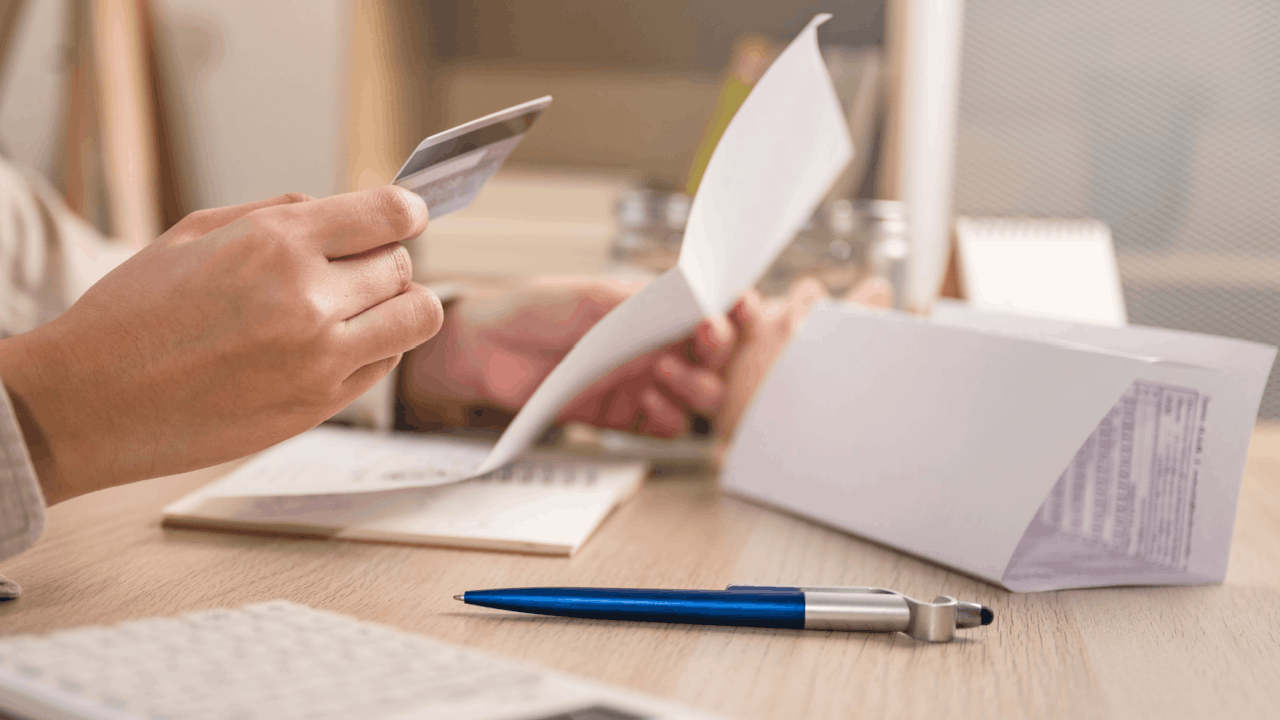 Person calculating debt amounts to determine Chapter 13 bankruptcy filing eligibility with credit card and financial documents