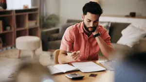 Man reviewing financial documents wondering how quickly can Chapter 13 be filed to stop creditor actions