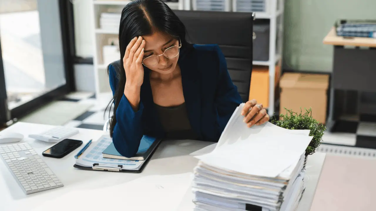 Woman reviewing documents after filing Chapter 13 bankruptcy at desk with paperwork