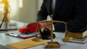 Bankruptcy attorney reviewing Chapter 13 documents with toy car and scales of justice showing can I keep my car in Chapter 13 legal consultation