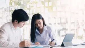 Chapter 13 eligibility requirements review with financial advisor and client examining bankruptcy documents and tablet