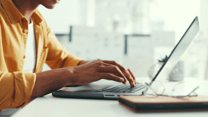 Person typing on a laptop researching is chapter 11 good or bad for their financial situation