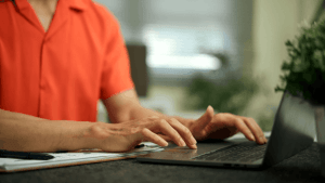 Person researching what two debts cannot be erased in bankruptcy on a laptop with financial documents nearby