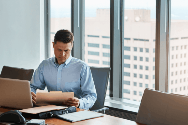 Attorney reviewing legal documents in a high-rise office to explain what's the difference between chapter 7 and 11 bankruptcy
