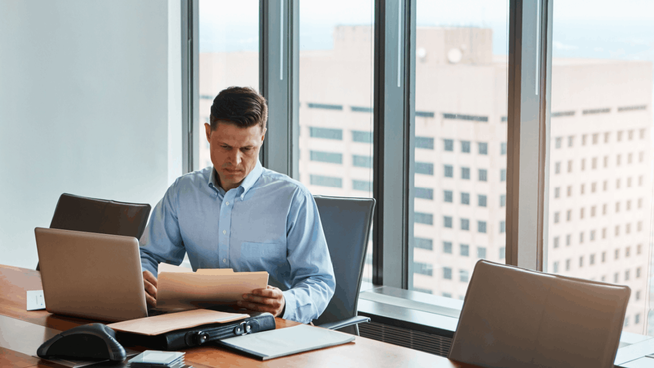 Attorney reviewing legal documents in a high-rise office to explain what's the difference between chapter 7 and 11 bankruptcy