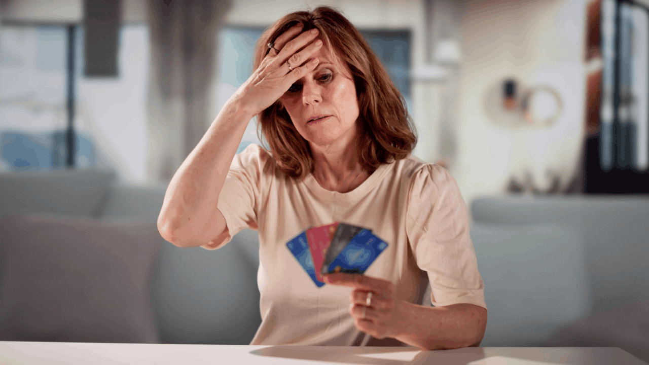 Woman overwhelmed by credit card debt holding multiple cards