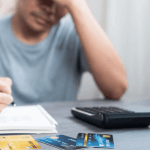 Man stressed over credit card debt at desk