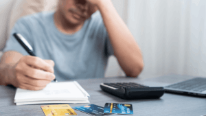 Man stressed over credit card debt at desk
