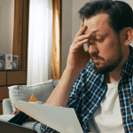 Man stressed over debt paperwork at home